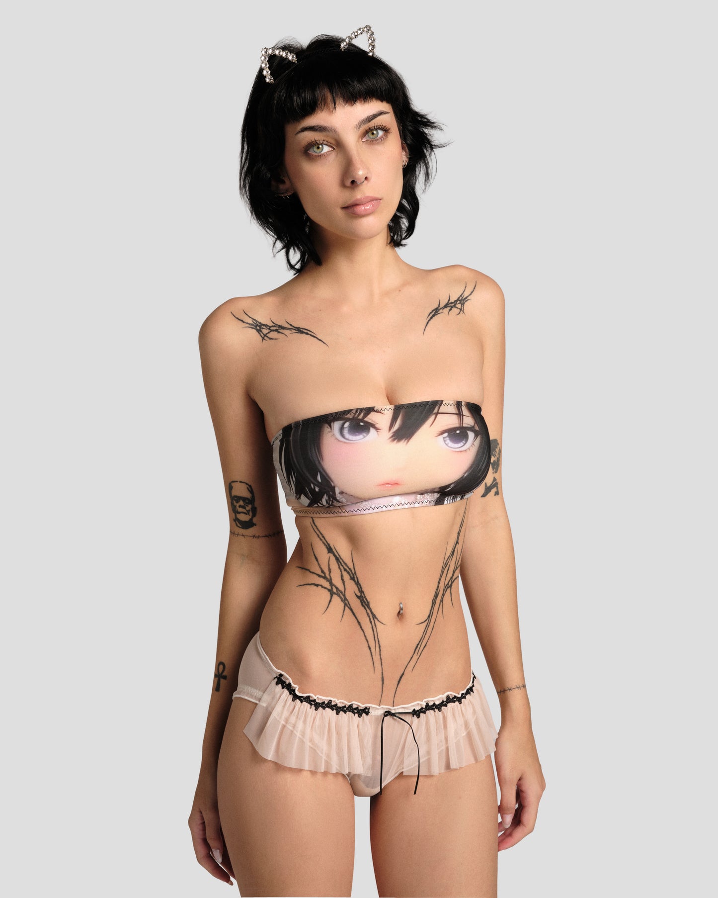 Model wearing a strapless top with an anime character design and matching underwear on a plain background